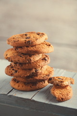 Cookies with chocolate crumbs on blue wooden table against blurred background, close up