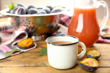Obraz na płótnie Canvas Plum Juice in jar and mug with fresh fruits