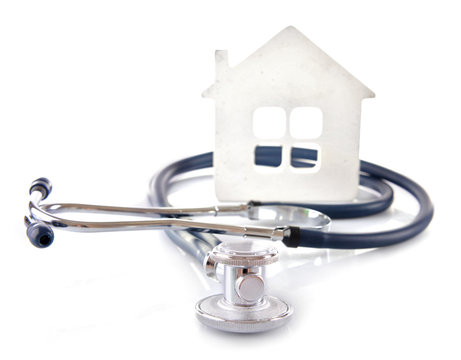 Concept of family medicine - white mini house and stethoscope isolated on white background
