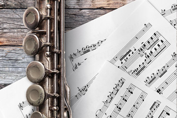 Obraz premium Old flute with sheet music on rusty wooden boards