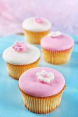 Tasty cupcakes on color wooden background