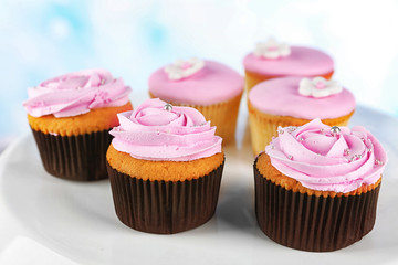Tasty cupcakes on color wooden background