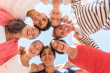 Under view of seven trendy teenagers arm in arm. 