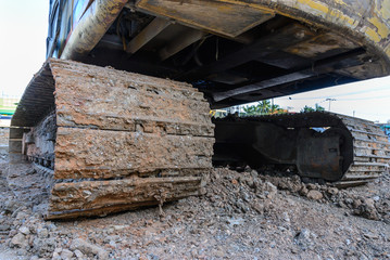 Dirty back hoe track at construction site.