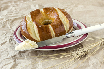 knife and a dab of butter complimented with a wheat stalk on brown rumpled paper for a background