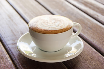 Hot coffee in a white cup on table