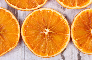Slices of dried orange on old wooden background