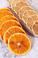 Slices of dried lemon and orange on old wooden background