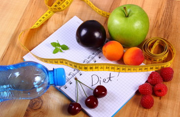 Fruits and centimeter with notebook, slimming and healthy food