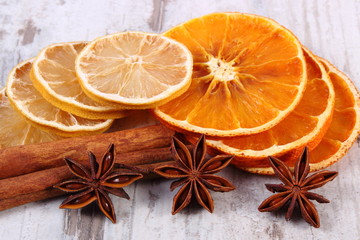 Slices of dried lemon, orange and spices on old wooden background