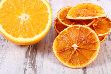Dried and fresh orange on old wooden background