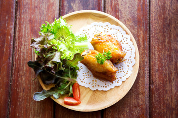 chicken wings with vegetables on wooden table