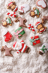 Fototapeta na wymiar Christmas gingerbread on white flour background. vertical top view 