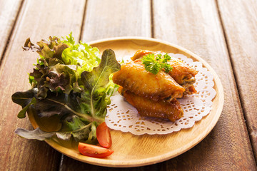 chicken wings with vegetables on wooden table