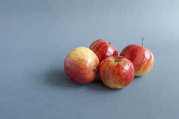 Fresh red mini apples on grey background