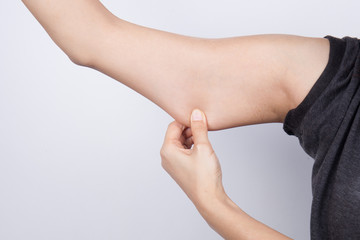 Young woman checking her arm fat
