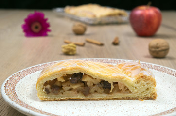 Homemade strudel with walnuts and red gerbera on a plate
