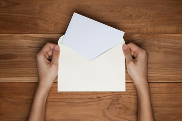 Obraz premium A female(woman) hand hold(open) a envelope and post card on the
