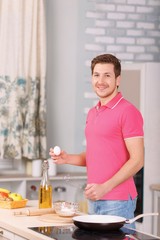 Father makes scrambled eggs for breakfast.