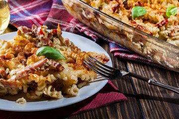Portion of fusilli pasta casseroles, sausages and zucchini
