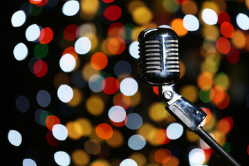 Fototapeta na wymiar Vintage microphone against defocused lights