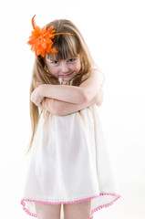 the young girl on the white dress  posing and pointing hand for the camera showing funny faces isolated on the white background