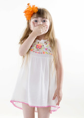the young girl on the white dress  posing and pointing hand for the camera showing funny faces isolated on the white background