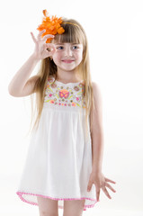the young girl on the white dress  posing and pointing hand for the camera showing funny faces isolated on the white background