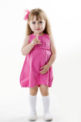 little girl in a pink dress posing for the camera showing funny faces