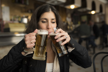 Woman drinking beer in bar