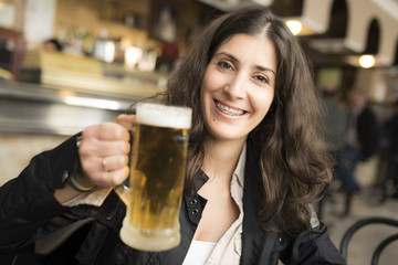 Woman drinking beer in bar