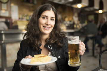 Woman drinking beer in bar