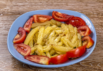 French fries with tomato and cheese on the plate on wooden background