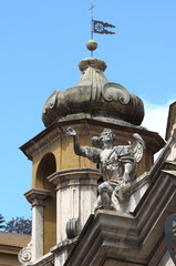 Fototapeta na wymiar Angel statue on top of baroque church in Rome, Italy