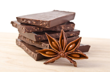 star of anise  and tower from chocolate  on wooden table