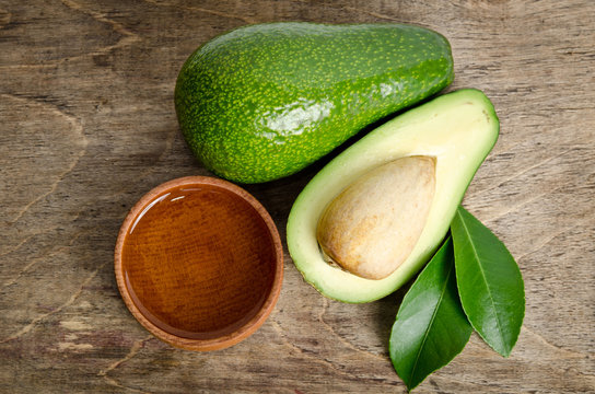 fresh avocado with avocado oil in the wooden bowl isolated on wo