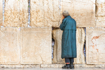 Israel, Jerusalem,a poor jewish faithful in prayer  at the western wall - obrazy, fototapety, plakaty