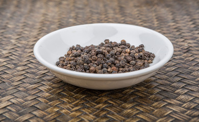 Black peppercorn over wicker background