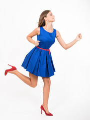 Running girl in blue dress, studio full length portrait