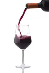 Fotobehang red wine poured into the glass on white © Orlando Bellini