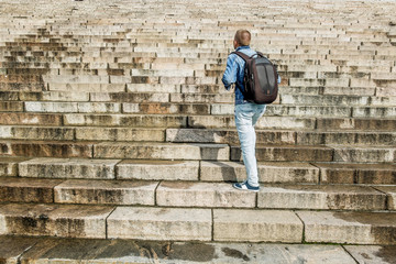 Fototapeta na wymiar Male tourist climbs up the granite stairs