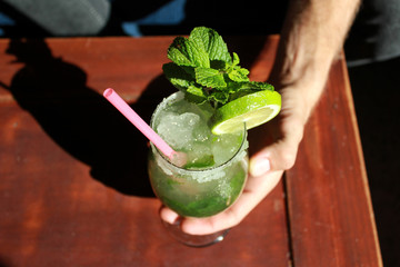 Hand holding a mojito drink 