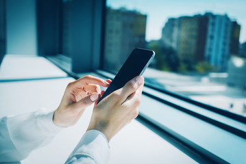 Girl touching a screen of her smarthone on the blurred background