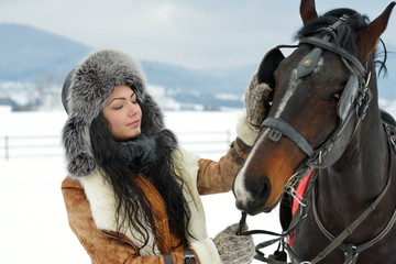 beautiful brunette woman portrait with horse in winter