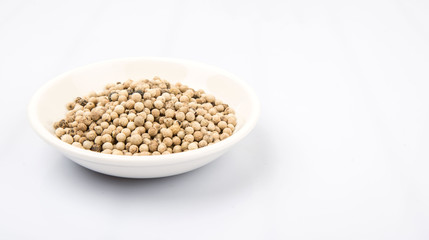 White peppercorn in white bowl over white background
