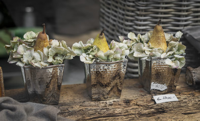 Decoration of shop windows - pears and hydrangea blooms in a vintage metal buckets. Soft focus. Vintage toning