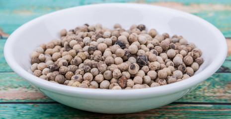 Dried lemon balm leaves in white bowl over wooden background