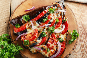 baked eggplant with cheese and tomatoes on a wooden surface