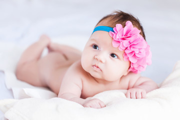Obraz na płótnie Canvas small cute baby girl with a adorable flower in her head