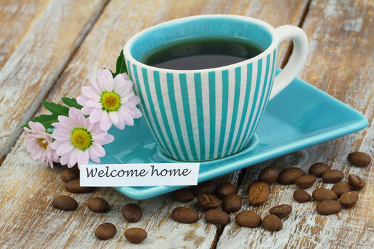 Welcome home card with cup of coffee and pink daisy flowers

